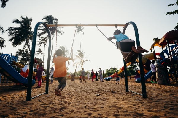 Kids swing and play on an outdoor playground, complete with all the accessories for hours of fun.