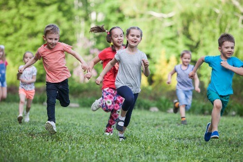Kids run together outside while getting all the benefits from playing.
